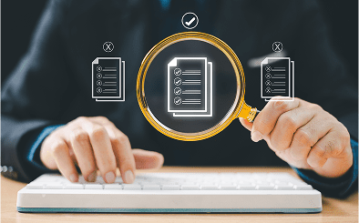 Magnifying glass over digital checklist on keyboard.